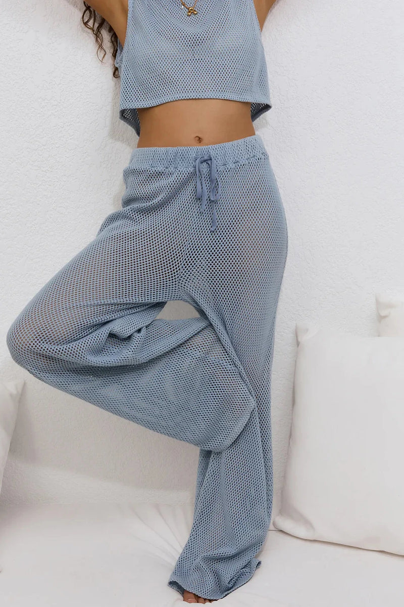 Person wearing blue checkered pants and a matching top on a white background
