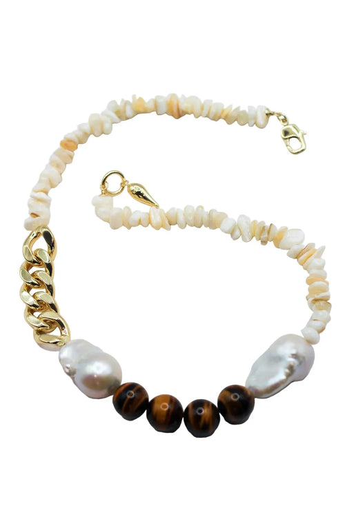 Necklace with gold chain, white pearls, and tiger eye beads on a light background