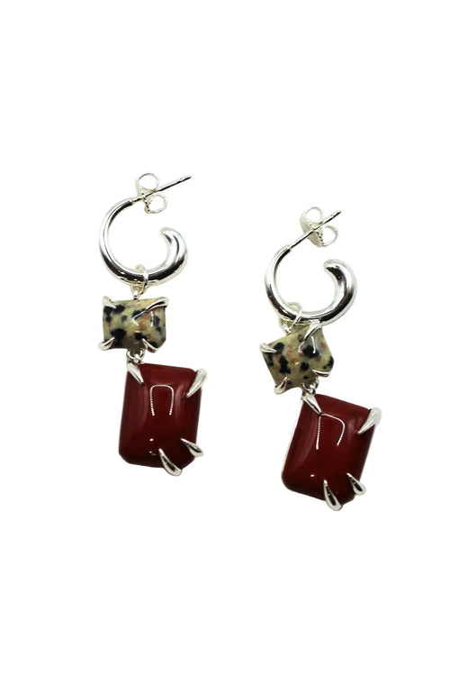 Pair of earrings with red rectangular stones and silver accents on a white background