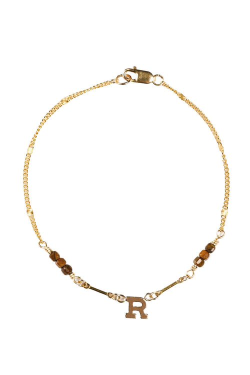 Gold bracelet with letter 'R' charm on a white background