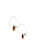 Gold hoop earrings with tortoiseshell beads on a white background
