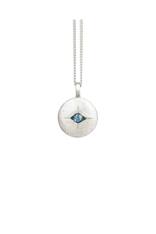 Silver necklace with a round pendant featuring a blue gemstone on a white background